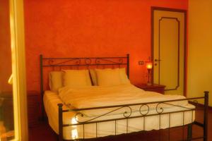 a bed in a bedroom with an orange wall at Casa Burnie in Monte Molino