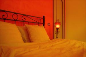 a bedroom with a bed with a red headboard and a lamp at Casa Burnie in Monte Molino