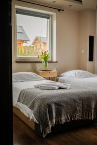 a bedroom with a bed and a window at Apartament nad Bukówką in Lubawka