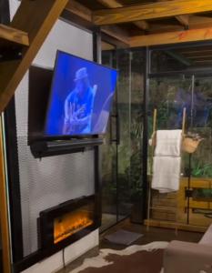 a living room with a tv and a fireplace at Hospedagem de Charme Te Amo in Canela