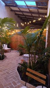 a patio with a bench and a bunch of plants at El Tapial in Chipiona