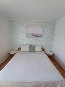 a bedroom with a large white bed with two tables at Guest House Radulj in Polače