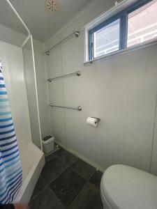 a bathroom with a shower and a toilet and a window at Mandurah Houseboat Just Chillin in Mandurah