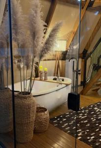 a bathroom with a white tub with feathers in it at Hospedagem de Charme Te Amo in Canela