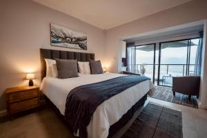 a bedroom with a large bed and a large window at Interlaken Guest House in Wilderness