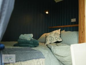 a bed with pillows on it in a bedroom at St Loy & Penberth Shepherds' Huts in Saint Buryan