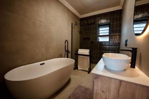 a bathroom with a large white tub and a sink at Interlaken Guest House in Wilderness +94 photos