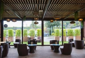 a restaurant with tables and chairs and windows at Alda Carballo in Carballo