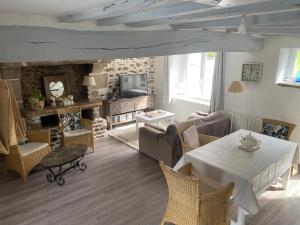 a living room with a white table and chairs at Belle maison renovée avec jardin terrasse -calme-proche mer -MESQUER in Mesquer