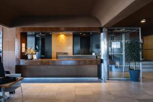 a lobby with a waiting area with a potted plant at Hotel America Igualada in Igualada