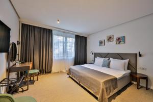 a hotel room with a bed and a desk at Hotel Botanica in Belgrade +54 photos