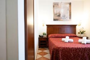 a bedroom with a red bed with two white towels at Hotel RomAntica in Rome +97 photos