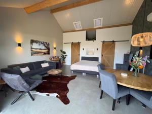 a living room with a couch and a bed at Weidezicht Soest, beauty & wellness en rust & natuur in Soest +32 photos
