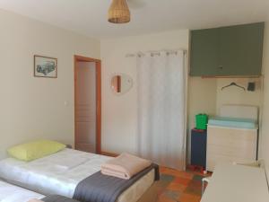 a small bedroom with a bed and a dresser at Au petit lieu-dit in Anglade +4 photos