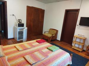 a bedroom with a bed and a tv and a chair at Proboyski Guest House in Tryavna