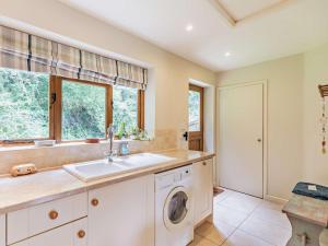 a kitchen with a sink and a washing machine at 1 Bed in Bampton oc-limkc in Bampton +13 photos