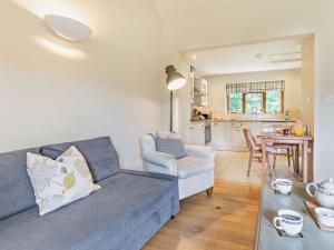 a living room with a blue couch and a kitchen at 1 Bed in Bampton oc-limkc in Bampton