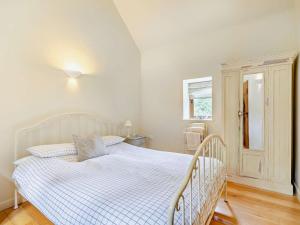 a bedroom with a white bed and a window at 1 Bed in Bampton oc-limkc in Bampton