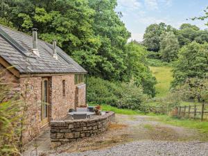 a stone house with a table and a stone wall at 1 Bed in Bampton oc-limkc in Bampton