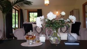 a table with a vase of white flowers on it at Beautiful Seasons in Wanaka