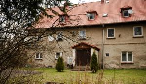 a large brick house with a red roof at Apartament nad Bukówką in Lubawka