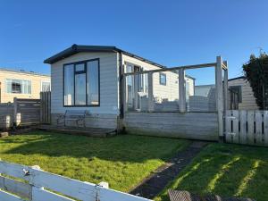 a tiny house in a yard with a fence at Noa aan Zee in Westerland