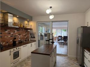 a kitchen with white cabinets and a brick wall at Borki Guest House in Smardzewice
