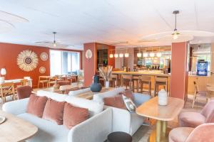 a living room with a couch and tables at BHOMA Bourges - Hôtel in Bourges +33 photos