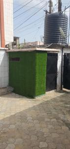 a green wall on the side of a building at Makepe Bungalow Style in Douala