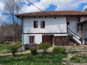 a white house with a red roof at Vitanova Guest House in Genchovtsi