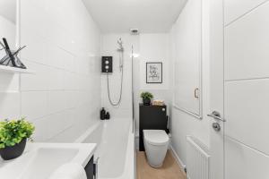 a white bathroom with a toilet and a sink at The Derby Escape - Garden -Sleeps 6 in Derby +13 photos