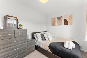 a bedroom with a bed with a dresser and a mirror at The Derby Escape - Garden -Sleeps 6 in Derby