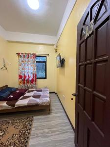 a bedroom with a bed and a door at Tipid Camp Baguio A2,A3,A7,A8 in Baguio