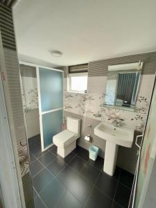 a bathroom with a toilet and a sink at Sleep Cheap Home in Negombo +20 photos