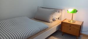 a bedroom with a bed with a lamp on a nightstand at Ferienwohnung Hofgarten in Ansbach