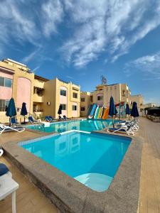 a large swimming pool with chairs and umbrellas at 4S Hotel Dahab in Dahab