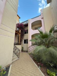 a walkway leading to a pink building with a balcony at 4S Hotel Dahab in Dahab