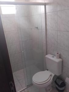 a bathroom with a toilet and a glass shower at residencial portuguesa in Parnamirim