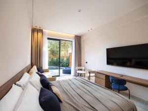 a hotel room with a large bed and a desk at Cabú Hotel Adults Only - Small Luxury Hotels of the World in Faliraki +69 photos