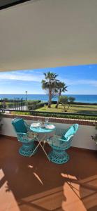 a table and chairs on a balcony with a view of the ocean at Peñoncillo Beach in Torrox Costa