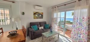 a living room with a couch and a table at Peñoncillo Beach in Torrox Costa +19 photos