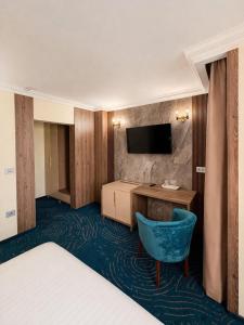 a hotel room with a bed and a desk and a chair at Hotel President in Arad