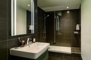 a bathroom with a sink and a shower at Bob W Munich City Centre in Munich