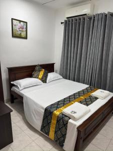 a bedroom with two beds and a window with curtains at Sleep Cheap Home in Negombo