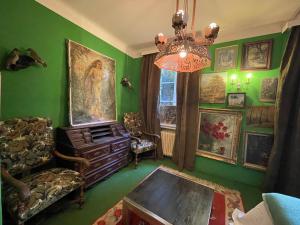 a living room with green walls and a chandelier at Oranienburg Vintage Hotel - Private Garden Residence in Vianden