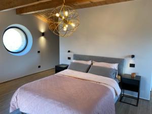 a bedroom with a large bed and a chandelier at Agriturismo Il Borghetto in Montedinove