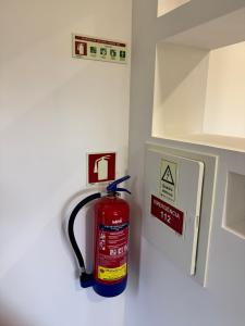 a fire hydrant in a kitchen with a fire extinguisher on the wall at A Casinha in Ventuzelo