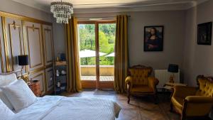 a bedroom with a bed and a chair and a window at BonBon Chambre d'hôtes in Saint-Julien-de-Lampon +45 photos