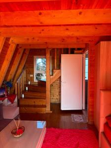 a living room with a staircase and a white door at Sea View Wooden Houses - Resort Sokoli in Lezhë