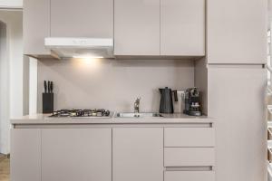 a kitchen with white cabinets and a sink at Elisabeth s Loft in Milan